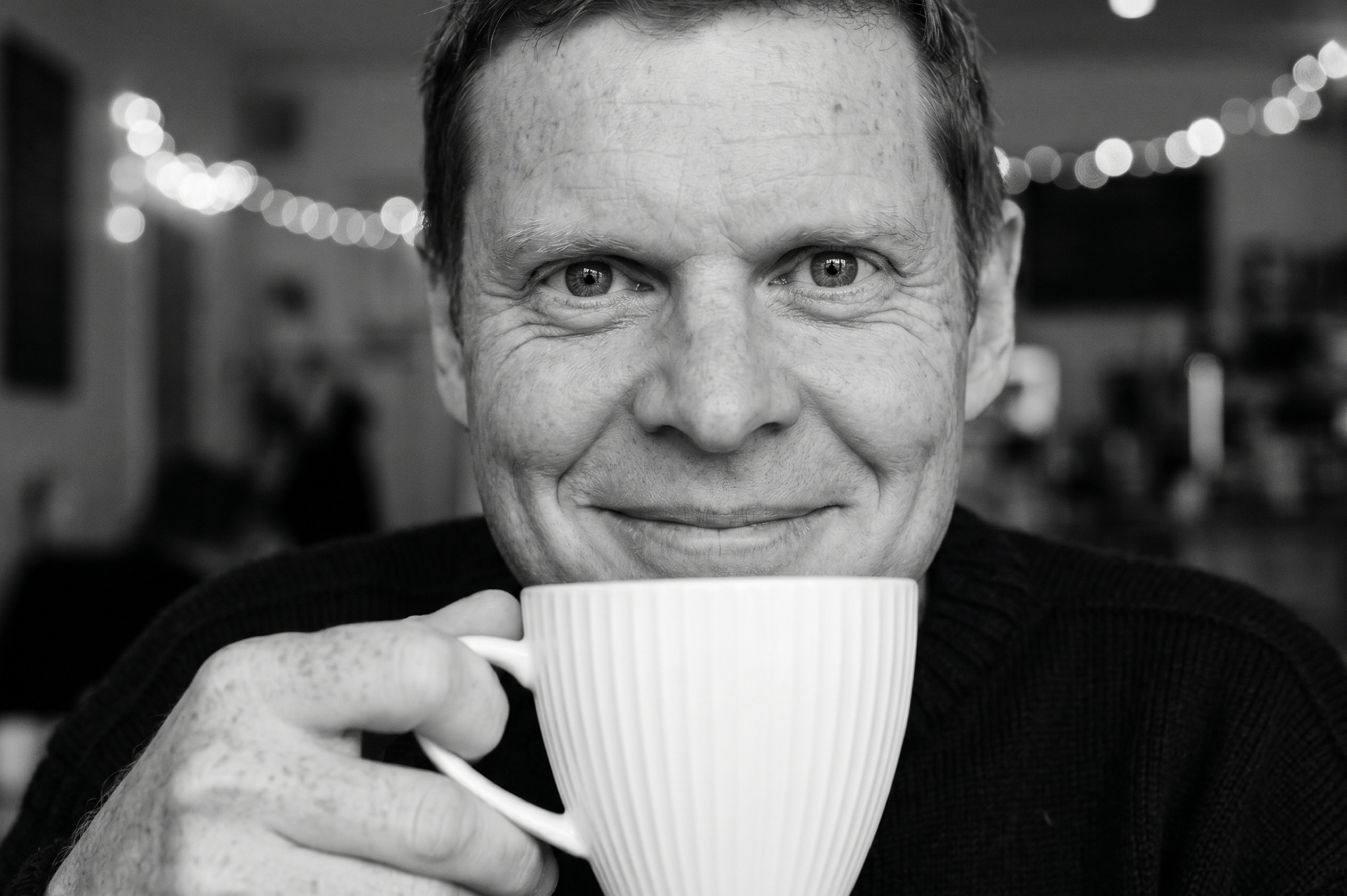 Marc Winn holding a coffee cup, smiling